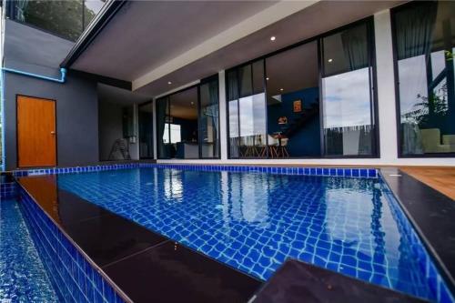 a swimming pool in a house with blue tiles at PoolVilla3 พักได้7ท่าน 3ห้องนอน4ห้องน้ำ in Doi Saket