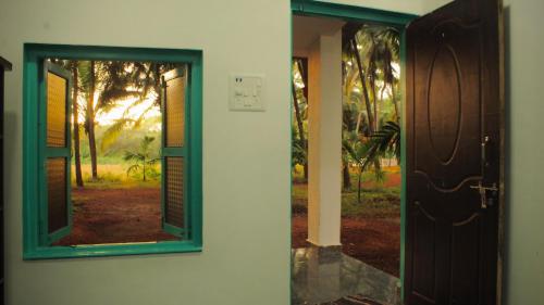 una puerta con ventana y vistas a un patio en India Yoga Village, en Canacona