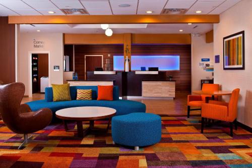 a lobby with a couch and a table and chairs at Fairfield Inn & Suites Houston Hobby Airport in Houston