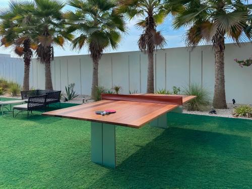 a ping pong table in a park with palm trees at Villa 72 RAK in Ras al Khaimah