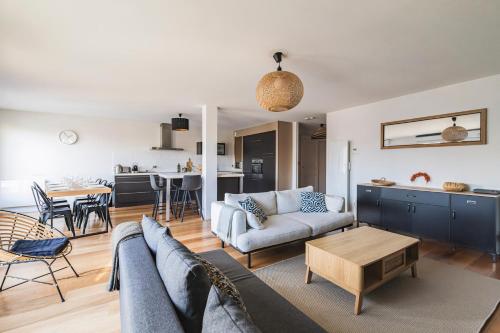 un salon avec un canapé et une table dans l'établissement La Parenthèse - spacieux 3 chambres - centre ville, à Reims