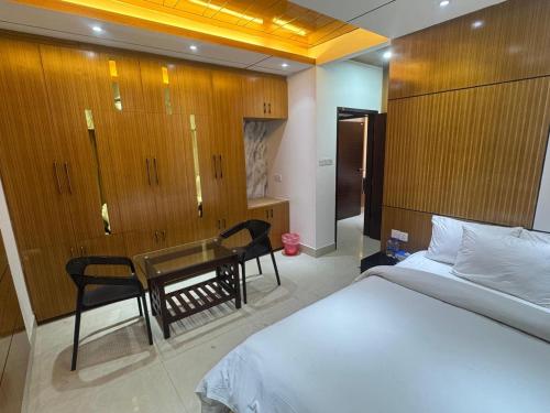 a bedroom with a bed and a table and chairs at The Castle Inn in Dhaka