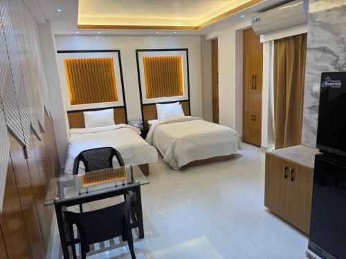 a hotel room with two beds and a television at The Castle Inn in Dhaka