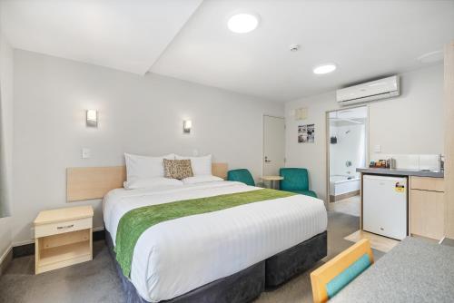 ファンガレイにあるBella Vista Motel Whangareiの大きなベッドとキッチンのある寝室