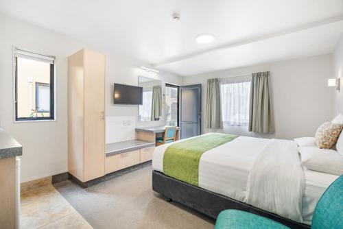 ファンガレイにあるBella Vista Motel Whangareiのベッドとテレビがあるホテルの部屋
