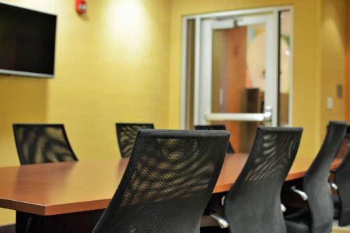 a conference room with a wooden table and black chairs at Fairfield Inn & Suites by Marriott Omaha Northwest in Omaha