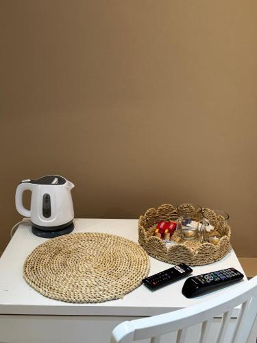 a table with a tea kettle and a basket of fruit at ESA Home in Warsaw