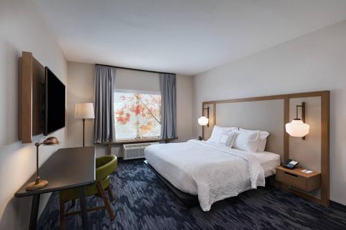 a hotel room with a bed and a desk and a window at Fairfield Inn & Suites by Marriott Houston Missouri City in Missouri City