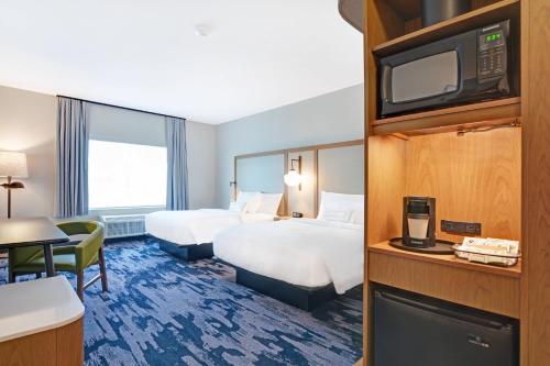 a hotel room with two beds and a flat screen tv at Fairfield Inn & Suites by Marriott Houston NASA/Webster in Webster
