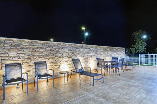 a group of chairs and tables in front of a stone wall at Fairfield Inn & Suites by Marriott Houston NASA/Webster in Webster