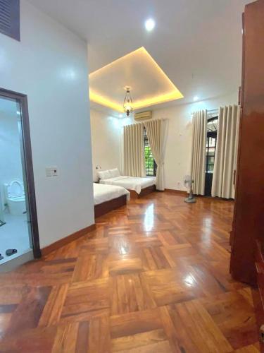a living room with a hard wood floor and a couch at Rose's Homestay Hue in Hue