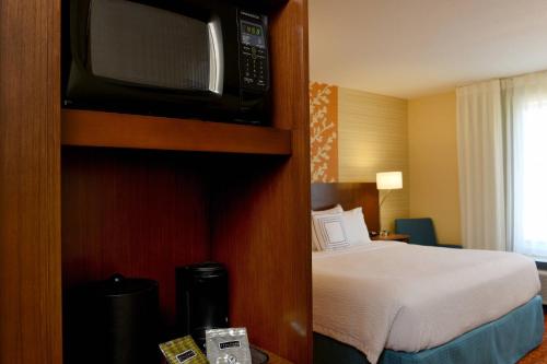 a hotel room with a bed and a microwave at Fairfield Inn & Suites by Marriott Omaha Papillion in Papillion
