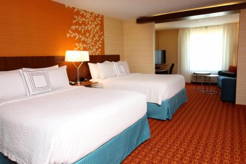 a hotel room with two beds and a couch at Fairfield Inn & Suites by Marriott Omaha Papillion in Papillion