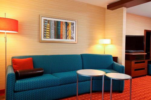 a living room with a blue couch and two tables at Fairfield Inn & Suites by Marriott Omaha Papillion in Papillion