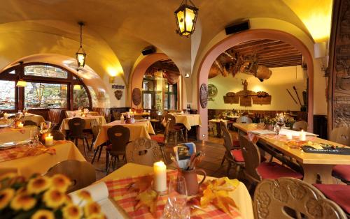 ein Restaurant mit Tischen und St&uuml;hlen in einem Zimmer in der Unterkunft Breuer's R&uuml;desheimer Schloss in R&uuml;desheim am Rhein