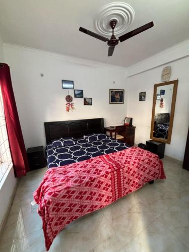 a bedroom with a bed with a red and black comforter at Ekaant Homestay in Bhowāli