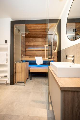a bathroom with a bed and a sink at Appartements Kuckuck Leogang in Leogang