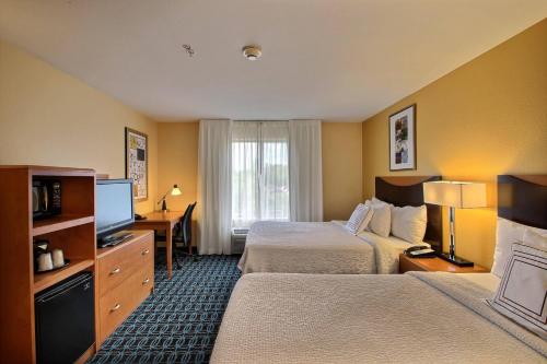 a hotel room with two beds and a television at Fairfield Inn & Suites by Marriott Milwaukee Airport in Oak Creek