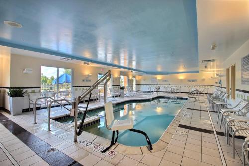 a swimming pool in a hotel room with chairs at Fairfield Inn & Suites by Marriott Milwaukee Airport in Oak Creek