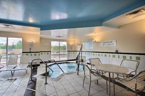 a swimming pool in a waiting room with a table and chairs at Fairfield Inn & Suites by Marriott Milwaukee Airport in Oak Creek