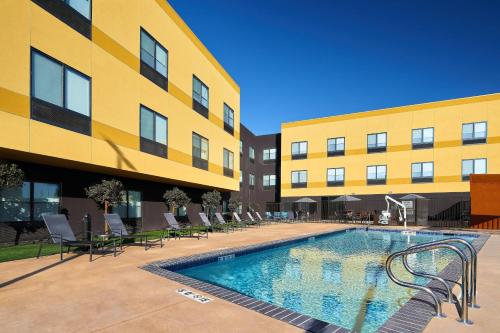 a swimming pool in front of a building at Fairfield Inn & Suites by Marriott Fresno Yosemite International Airport in Fresno