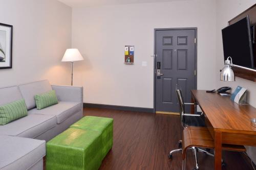 a living room with a couch and a table and a desk at Four Points By Sheraton Mount Prospect O’Hare in Mount Prospect
