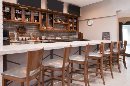 a bar with a row of chairs around it at Four Points By Sheraton Mount Prospect O’Hare in Mount Prospect