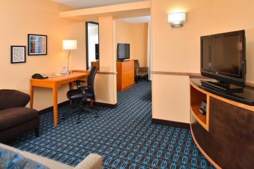 a hotel room with a desk and a flat screen tv at Fairfield Inn & Suites by Marriott Helena in Helena