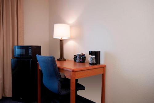 a room with a desk with a lamp and a blue chair at Fairfield Inn by Marriott Joliet South in Joliet