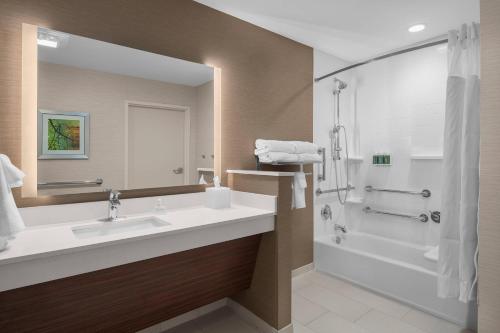 a bathroom with a sink and a tub and a shower at Fairfield Inn & Suites by Marriott Memphis Marion, AR in Marion