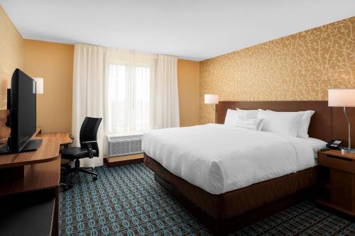 a hotel room with a bed and a desk and a television at Fairfield Inn & Suites by Marriott Memphis Marion, AR in Marion