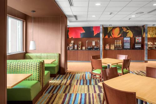 a restaurant with green chairs and tables and tables and tablesktop at Fairfield Inn & Suites by Marriott Memphis Marion, AR in Marion
