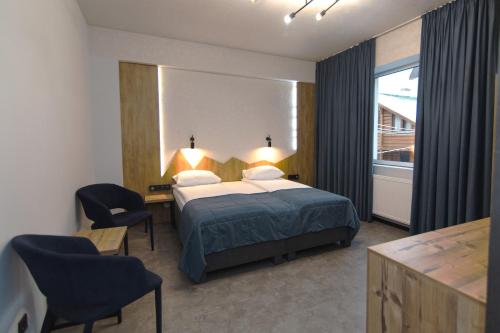 a hotel room with a bed and a desk and chairs at Синя гора in Bukovel