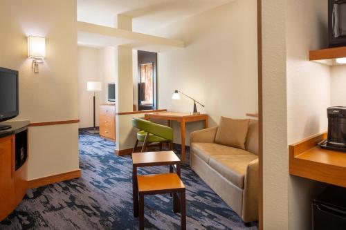 a hotel room with a couch and a desk at Fairfield Inn & Suites by Marriott Selma Kingsburg in Kingsburg