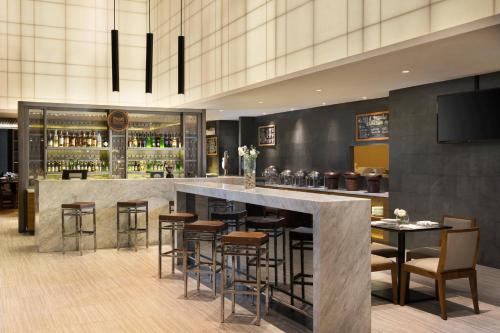 a bar in a restaurant with bar stools at Four Points by Sheraton Jakarta Thamrin in Jakarta