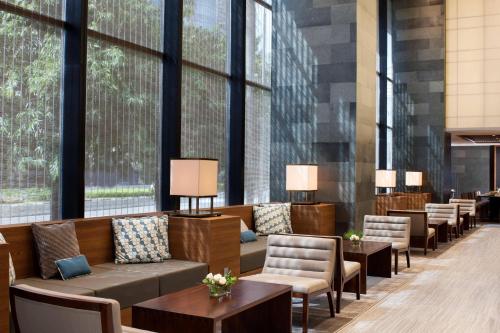 a lobby with chairs and tables and large windows at Four Points by Sheraton Jakarta Thamrin in Jakarta