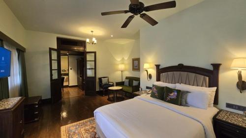 a bedroom with a large bed with a ceiling fan at Gateway Madurai in Madurai