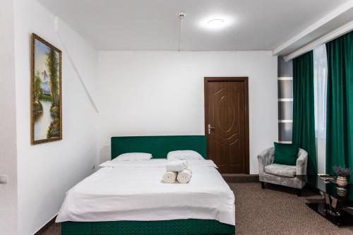 a bedroom with a bed with a green headboard at Star Rent Hotel in Chişinău