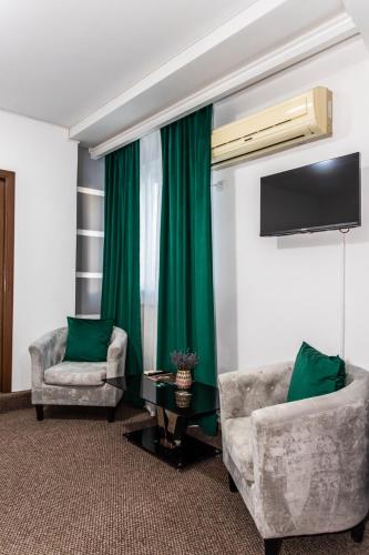 a living room with two chairs and a green curtain at Star Rent Hotel in Chişinău