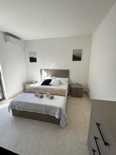a bedroom with a large bed in a white room at New Stylish 2 Bedroom Apartment in Msida in Taʼ Xbiex