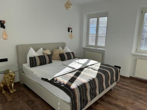 a bedroom with a bed with white sheets and pillows at Club Alpenresidenz Gastein in Bad Gastein