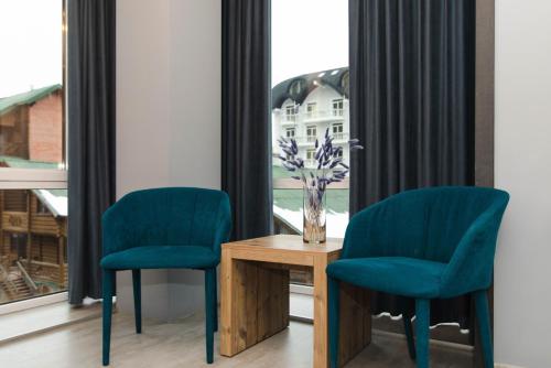 two chairs and a table in front of a window at Синя гора in Bukovel