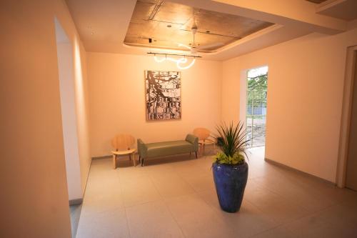 a waiting room with a green couch and a potted plant at RIVERSCAPES by NOORJEHAN in Palakkad