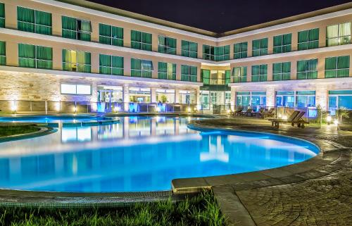 a hotel pool in front of a building at night at Howard Johnson Neuquen in Neuquén