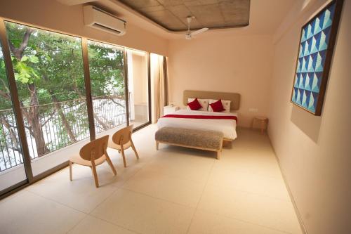 a bedroom with a bed and two windows at RIVERSCAPES by NOORJEHAN in Palakkad