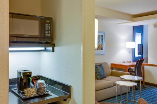 a living room with a couch and a microwave at Fairfield Inn and Suites by Marriott Titusville Kennedy Space Center in Titusville