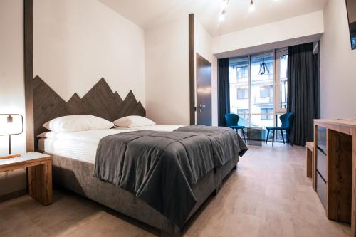 a bedroom with a large bed and a large window at Синя гора in Bukovel