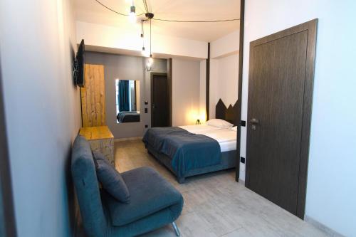 a bedroom with a bed and a chair and a couch at Синя гора in Bukovel