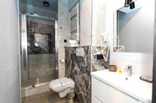 a bathroom with a toilet and a sink and a shower at Синя гора in Bukovel