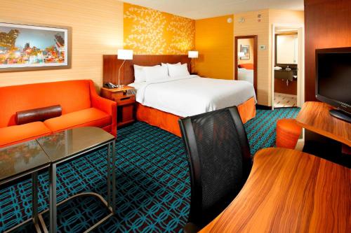 a hotel room with a bed and a couch at Fairfield Inn by Marriott East Rutherford Meadowlands in East Rutherford